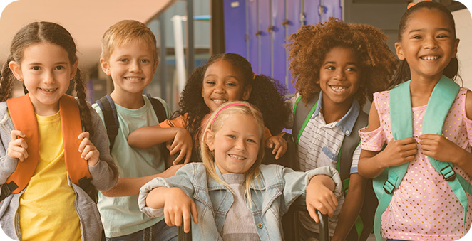 Grupo de crianças sorrindo em um corredor de escola.