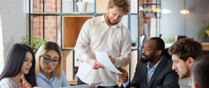 Grupo diversificado de colegas de trabalho tendo uma discussão casual no escritório.