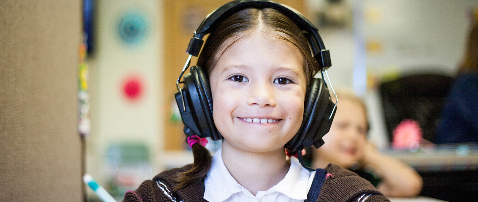 Menina sorridente com fone de ouvido na escola.