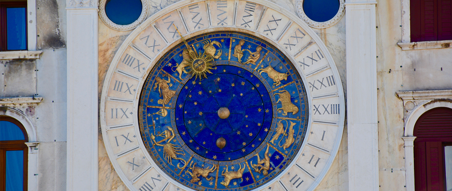 Relógio com números romanos e figuras da astrologia