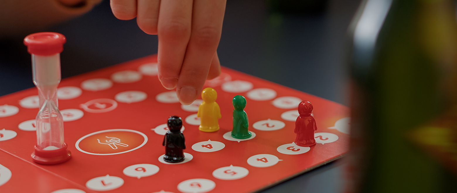 Jovens jogando jogos de tabuleiro de charadas com estatuetas