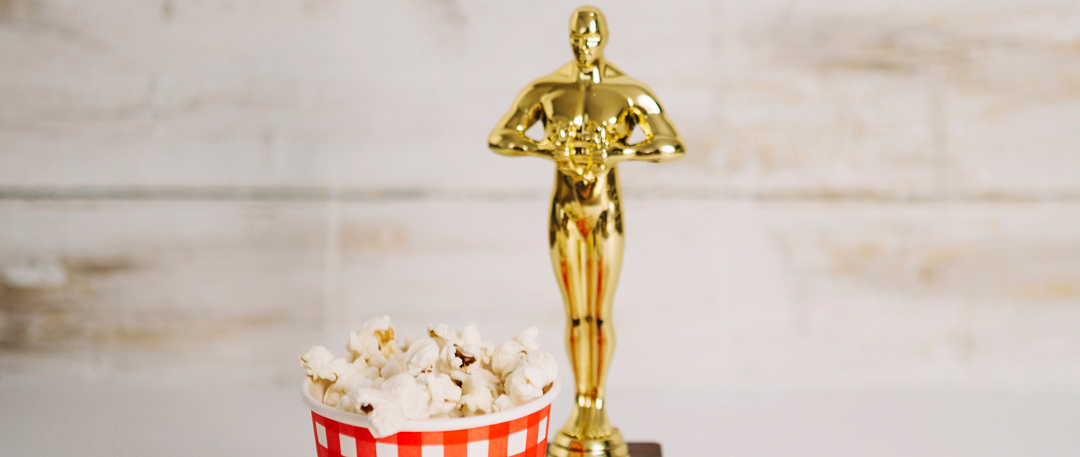 Imagem da estatueta do Oscar com um balde de pipoca