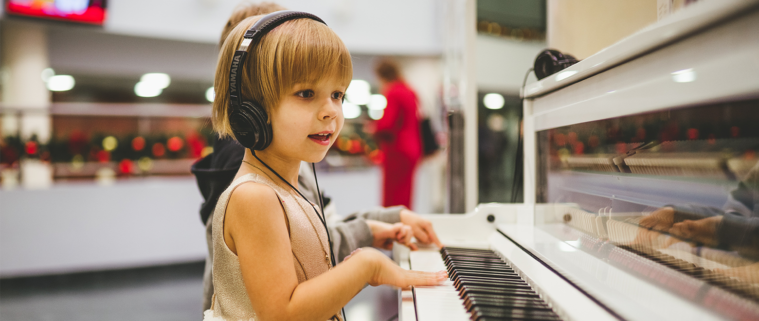 Menina ouvindo música com fones de ouvido e tocando piano